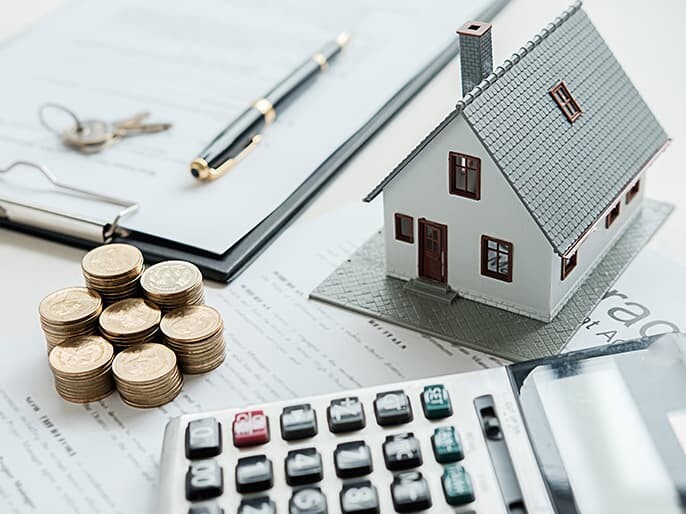 早急に現金化できることを表すイメージ写真（住宅模型・現金・電卓）